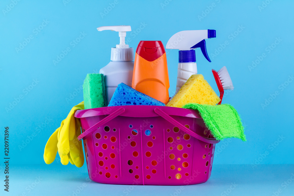 Basket with cleaning products on blue background. Cleaning with