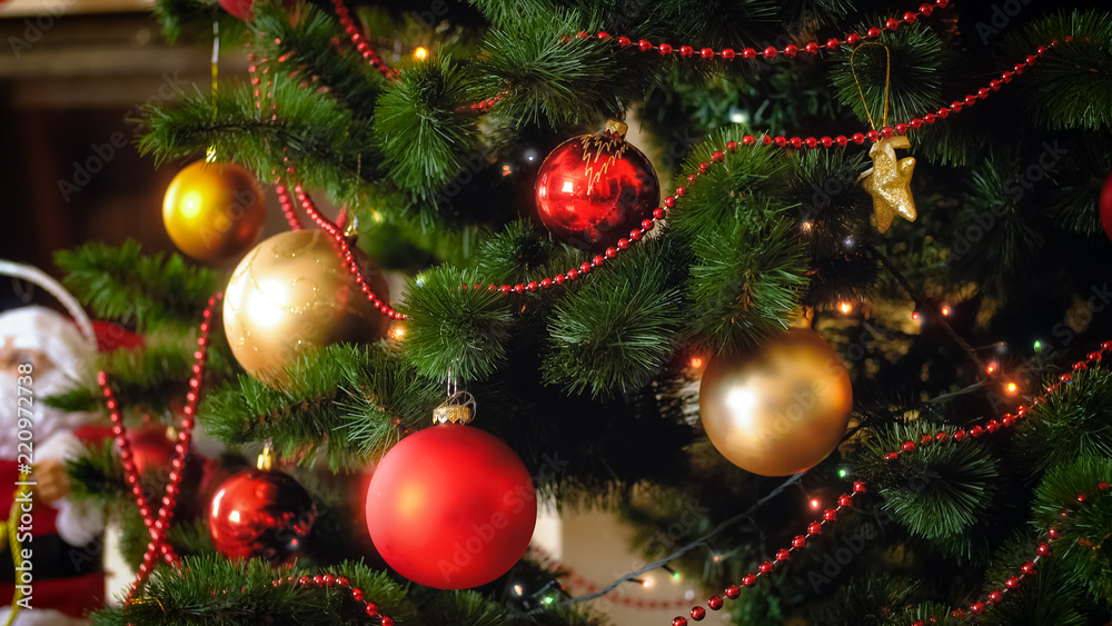Closeup image of beautiful colorful balls and glowing lights on Christmas tree