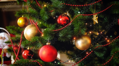 Closeup image of beautiful colorful balls and glowing lights on Christmas tree
