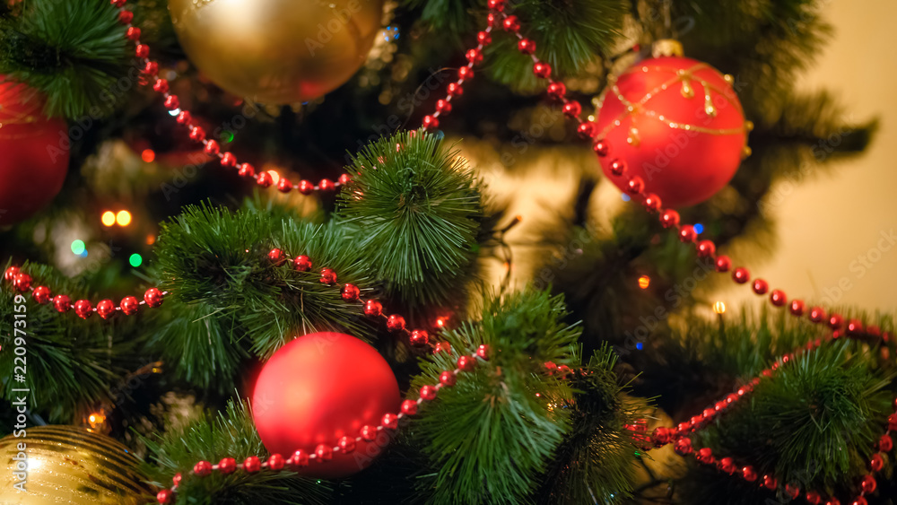 Closeup image of red and golden baubles adorning Christmas tree