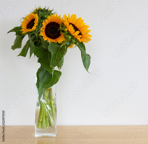 Sunflowers in a glass vase on the table.