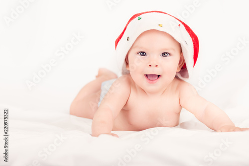 Xmas card with cute baby girl with santa hat on beige airy briht background with copy space photo