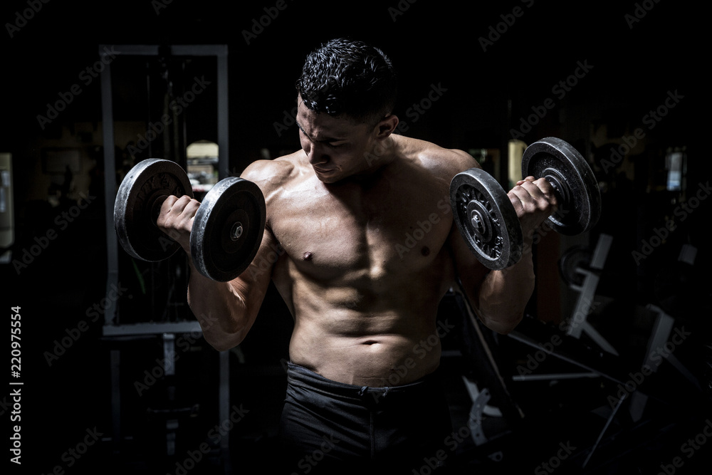 Young man exercising in dark and old gym