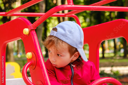 Boy playing on playground carousel in the park © bravissimos