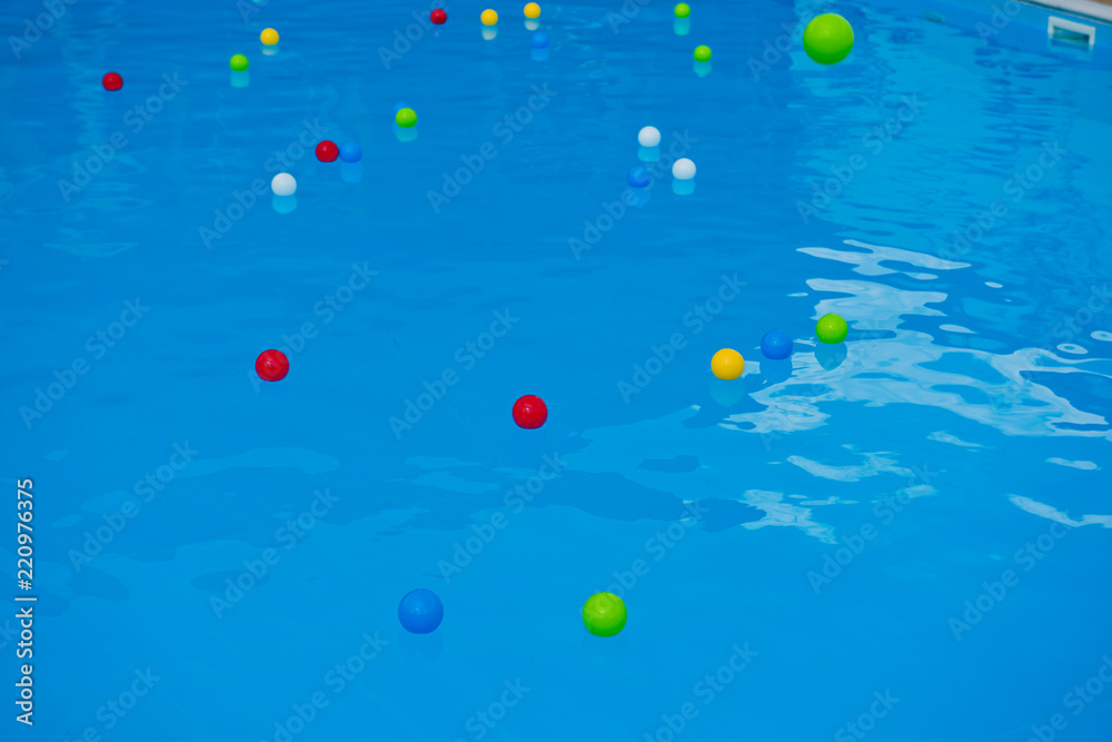 Multicolored balls on the surface of the blue pool. Multicolored balls on the surface of the blue pool.