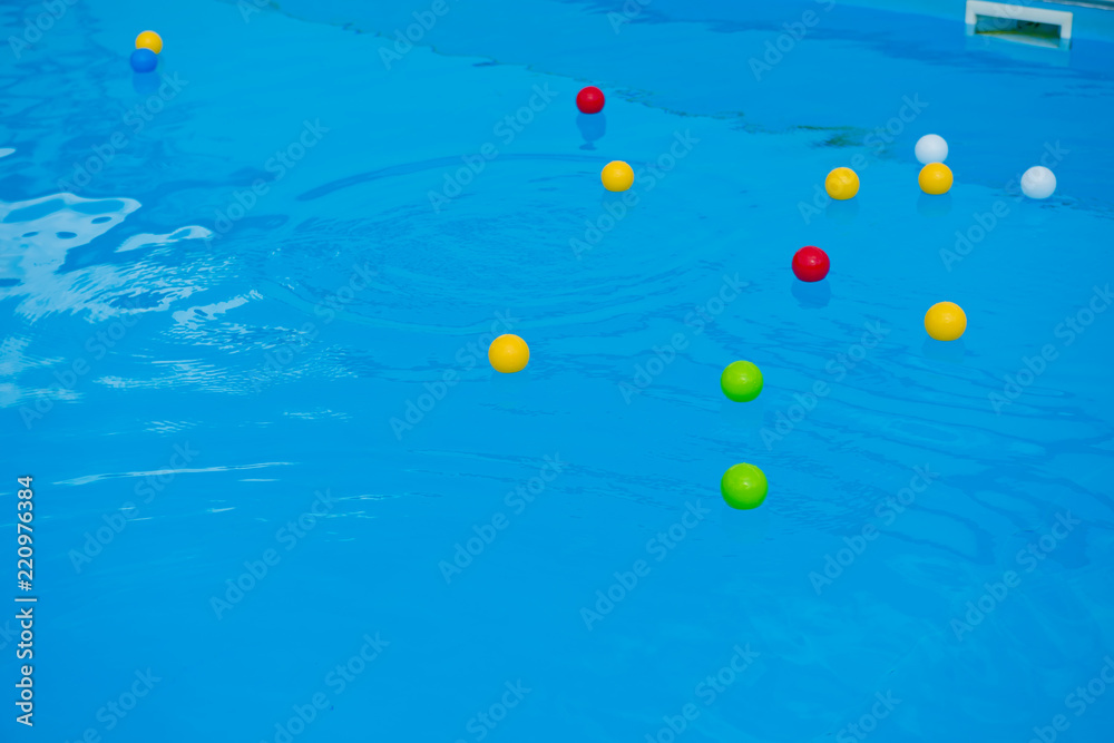 Multicolored balls on the surface of the blue pool. Multicolored balls on the surface of the blue pool.