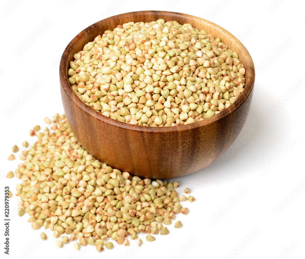 uncooked buckwheat isolated in the wooden bowl, on the white background