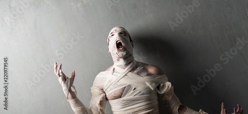 Terrorific mummy screaming on textured wall background.  Halloween holidays photo