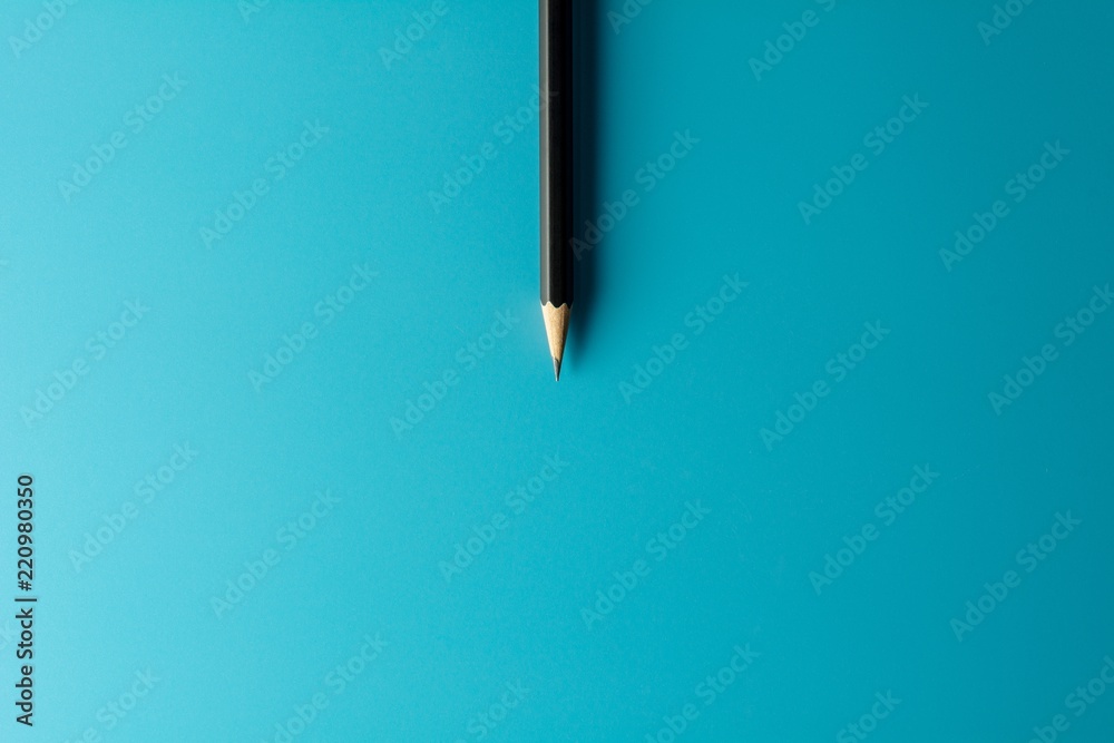 Black pencil on blue paper background. - Business concept. Black pencil on blue paper background. - Business concept.