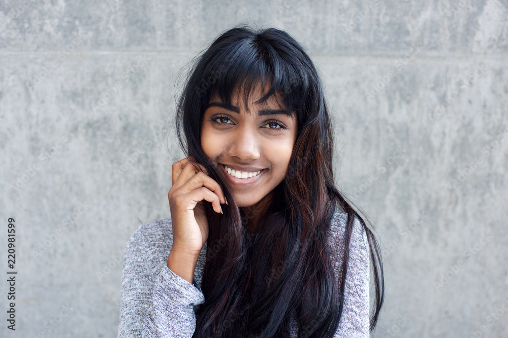 Naklejka premium young Indian woman smiling with hand in hair