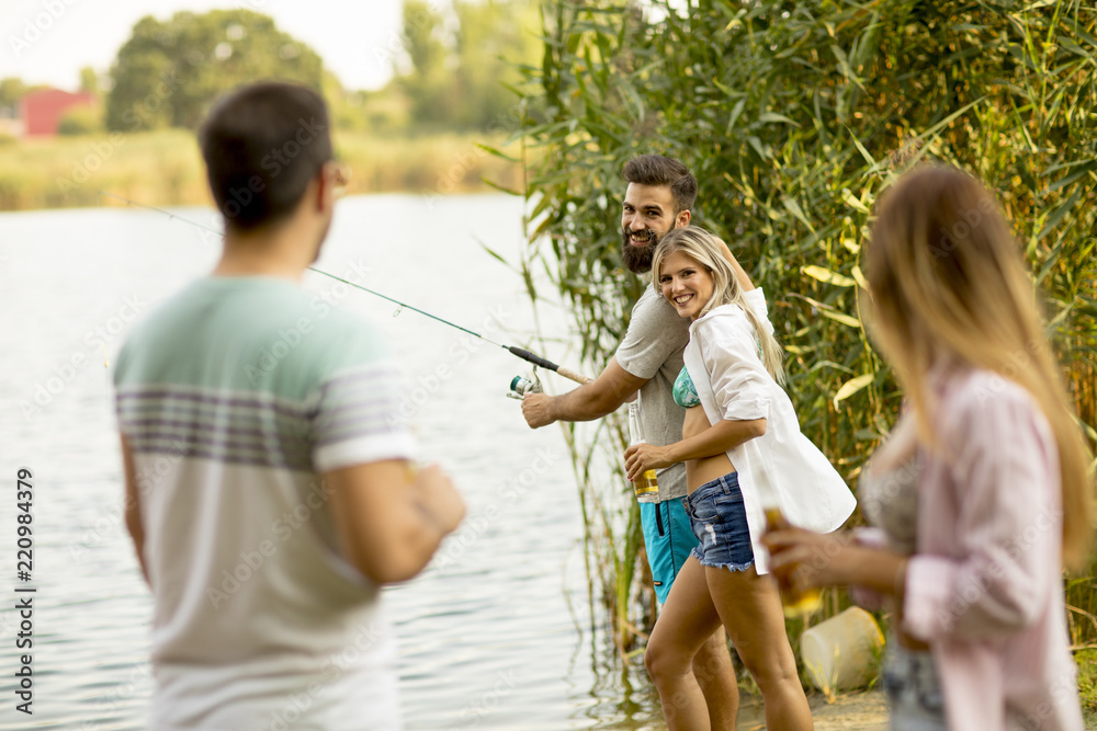 Fototapeta premium Young people enjoy fishing on river