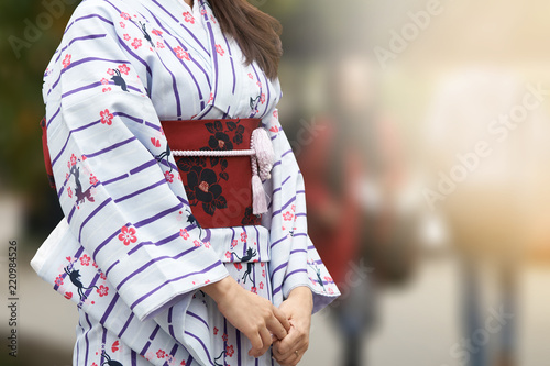 Young girl wearing Japanese kimono standing in front of Sensoji Temple in Tokyo, Japan. Kimono is a Japanese traditional garment. The word "kimono", which actually means a "thing to wear"