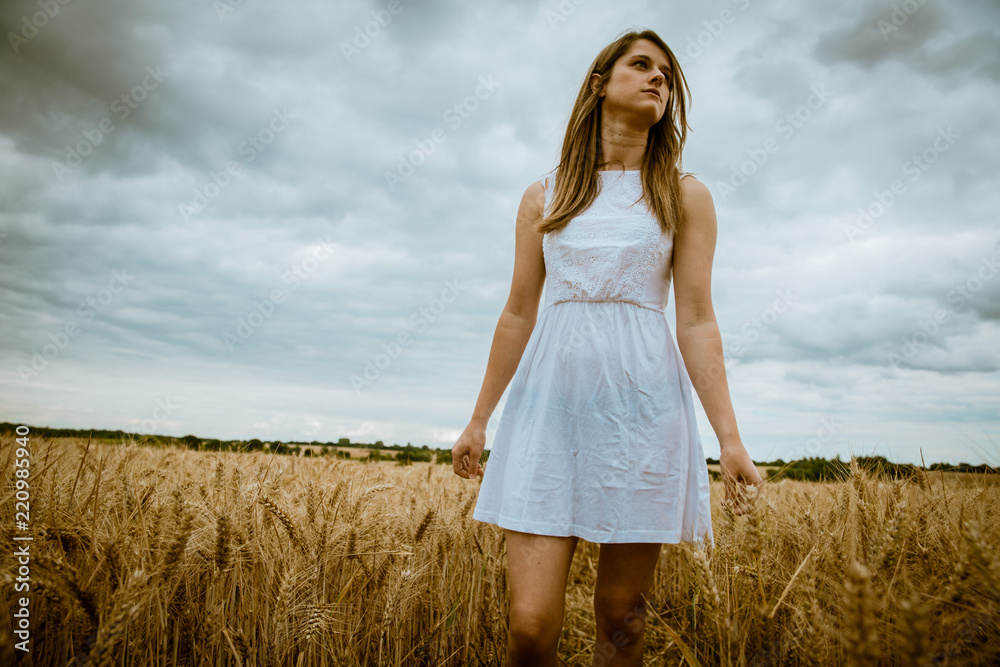 Young blond girl white dress walking in a cornfield Young blond girl white dress walking in a cornfield