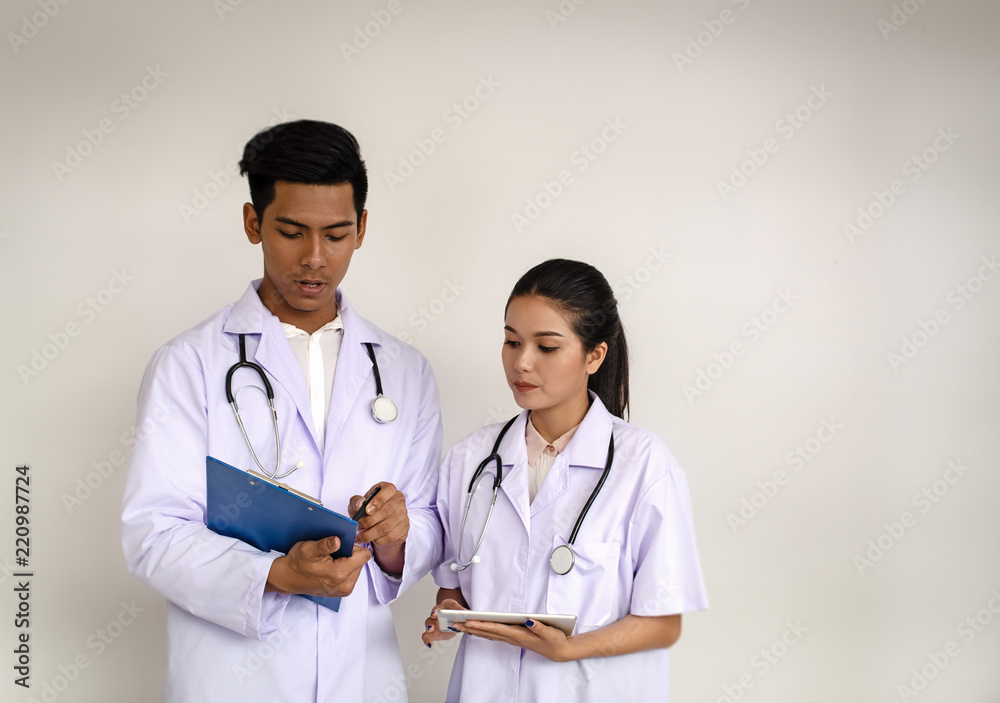 Two doctors are consulting about the patient symptoms together,at hospital,blurry light around Two doctors are consulting about the patient symptoms together,at hospital,blurry light around
