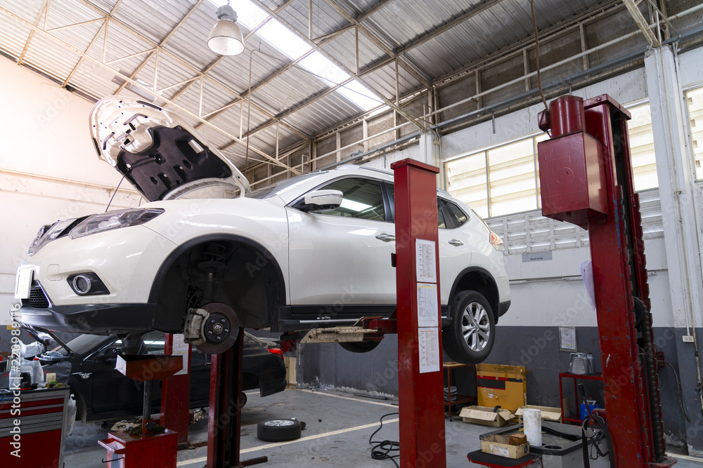 Fototapeta premium A car is lifted on a bridge in a car garage