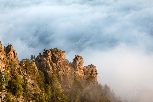 Rocks cliff with fog in mountains