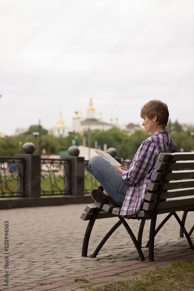 Happy woman sitting and reading a book Happy woman sitting and reading a book