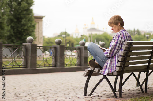Happy woman sitting and reading a book