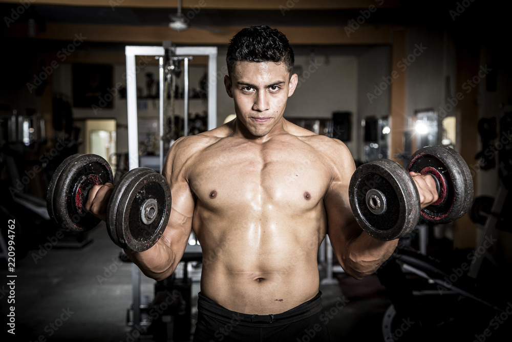 Young man exercising in dark and old gym Young man exercising in dark and old gym