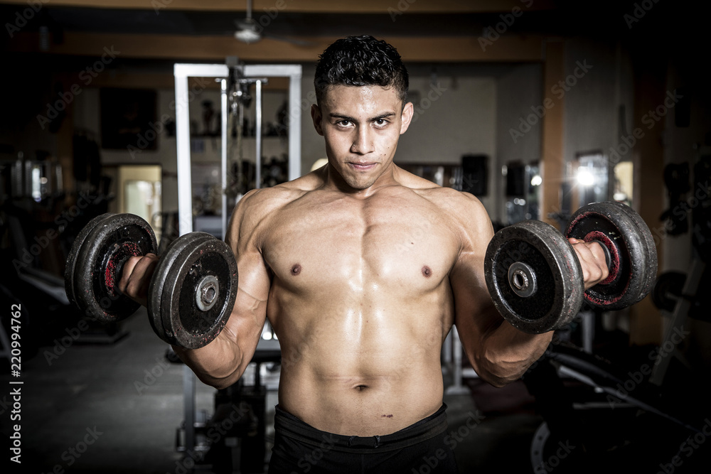 Young man exercising in dark and old gym