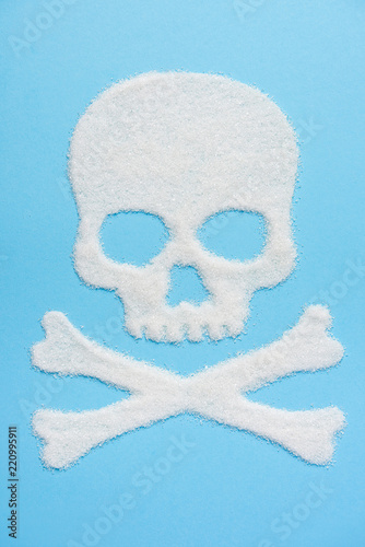 The skull made of sugar on blue blue background. Diabetes concept. Sugar Kills. Suggesting dieting concept. Copy space