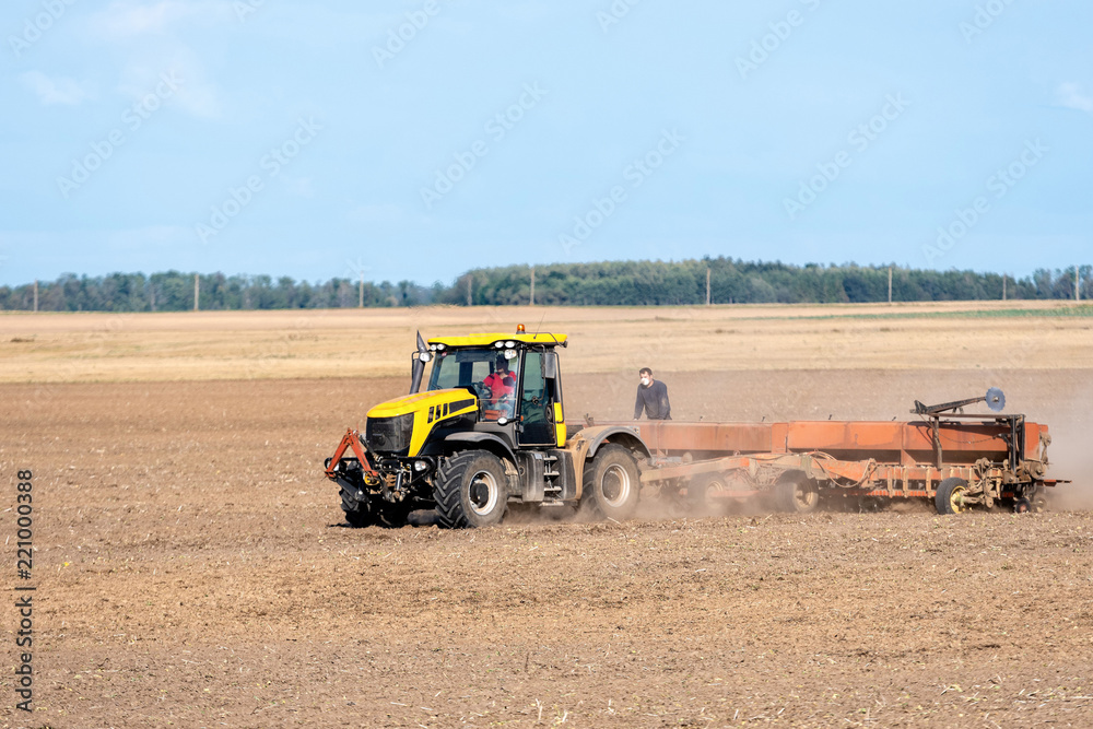 Obraz premium In the autumn, the farmer processes the fields with the tractor and sows the seeds for the next harvest.