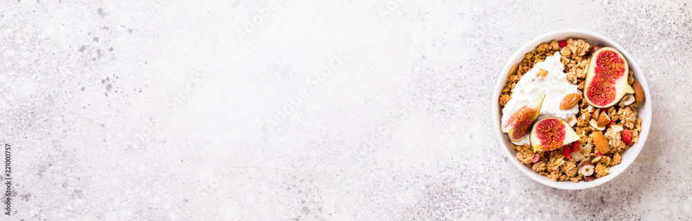 Muesli with Nuts Yogurt and fresh Figs on the gray Background.Granola Healthy Breakfast. Sweet food Dessert. Snack  Dry Diet Nutrition Concept.Top View. Flat Lay.Copy space for Text.Banner