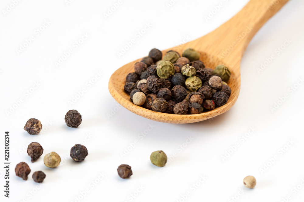 Different peppercorn in a wooden spoon.