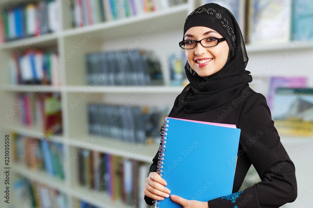 Close-up Beautiful Young Muslim Woman with notebooks on blurred Close-up Beautiful Young Muslim Woman with notebooks on blurred