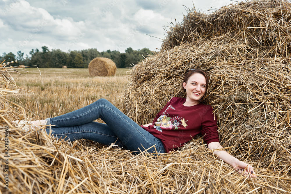 young girl having fun in the field, lying on a haystack young girl having fun in the field, lying on a haystack