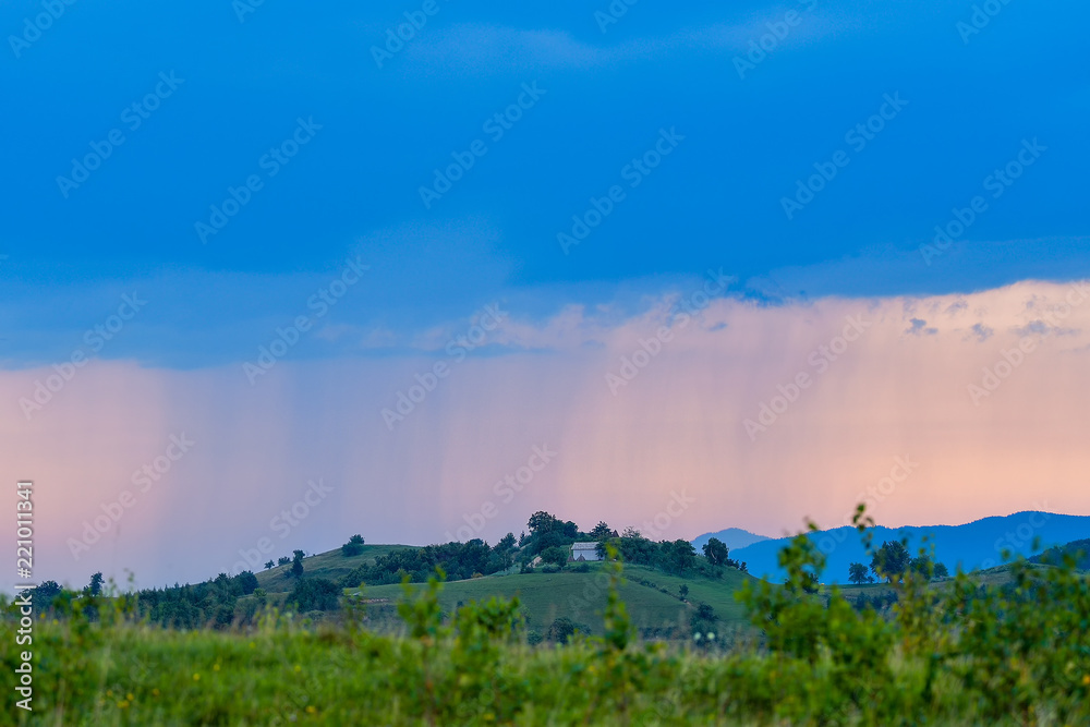 Rural landscape with rain storm over the meadow