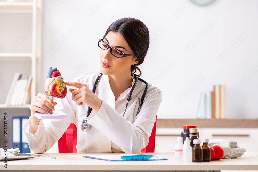Woman doctor showing heart model to students Woman doctor showing heart model to students