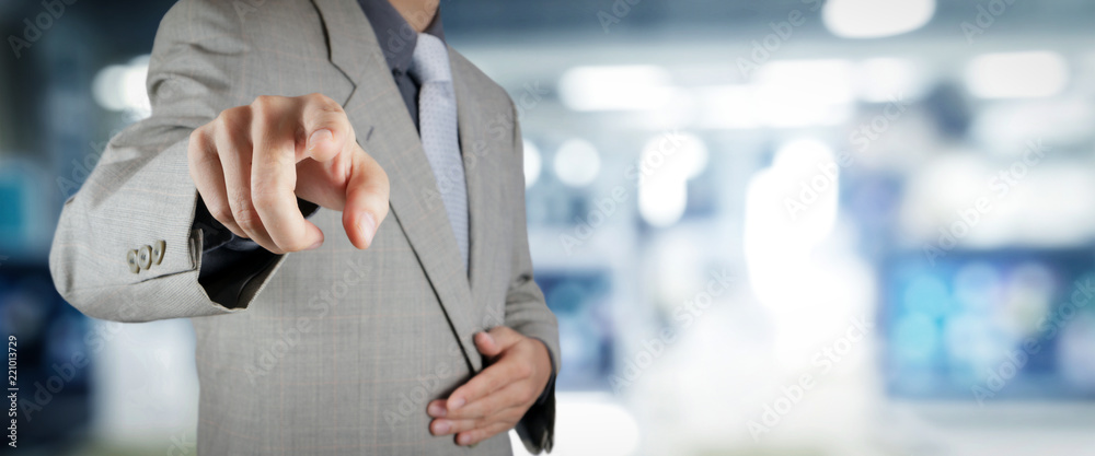 businessman workimg on VR blank wide touch screen computer on office blur background.