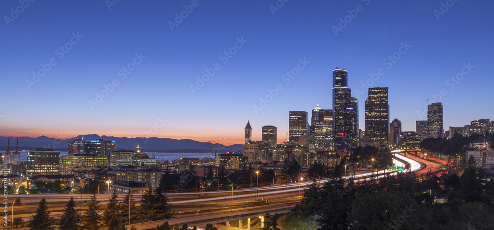 Obraz premium A long exposure of the Seattle skyline with car light trails