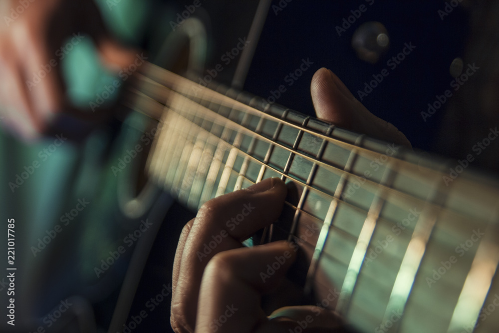 Fototapeta premium Musician man is playing the guitar on the concert