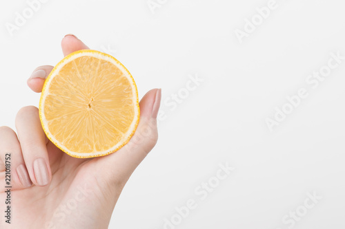  Female hands holding a lemon, orange, kiwi on a white background