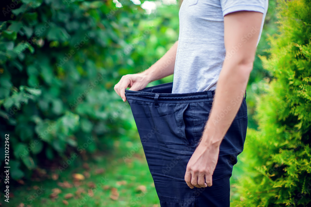 Ταπετσαρία Young man wearing big loose jeans - weight loss concept