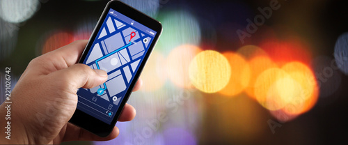 Close up of Tourist using GPS map navigation on smartphone application screen for direction to destination address in the city with travel and technology concept.