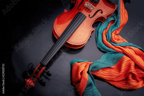 violin on a black table with a color scarf