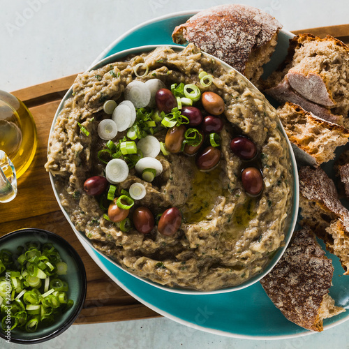 Appetizer with baba ganush of eggplant, olives from kalamata, green onions and fresh rye bread. Mediterranean snack. Vegan healthy food photo