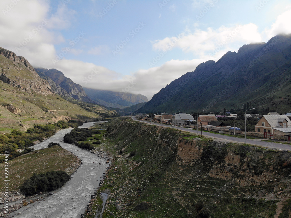 A village on the banks of a turbulent river in the Caucasus mountains.