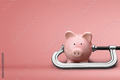 Pink piggy bank and clamp on background photo