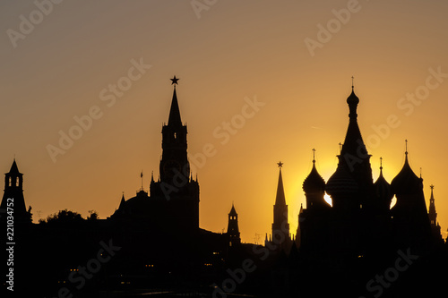 Black silhouettes of the towers of the Moscow Kremlin and St. Basil's Cathedral on the red square. Sunset evening view.