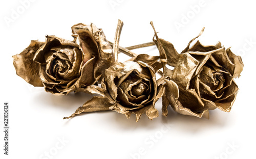 Three gold roses isolated on white background cutout. Golden dried flower heads, romance concept.