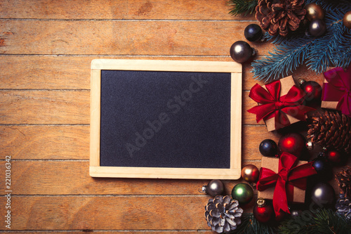 blackboard with Christmas decoration around on wooden table. Above view in old color style