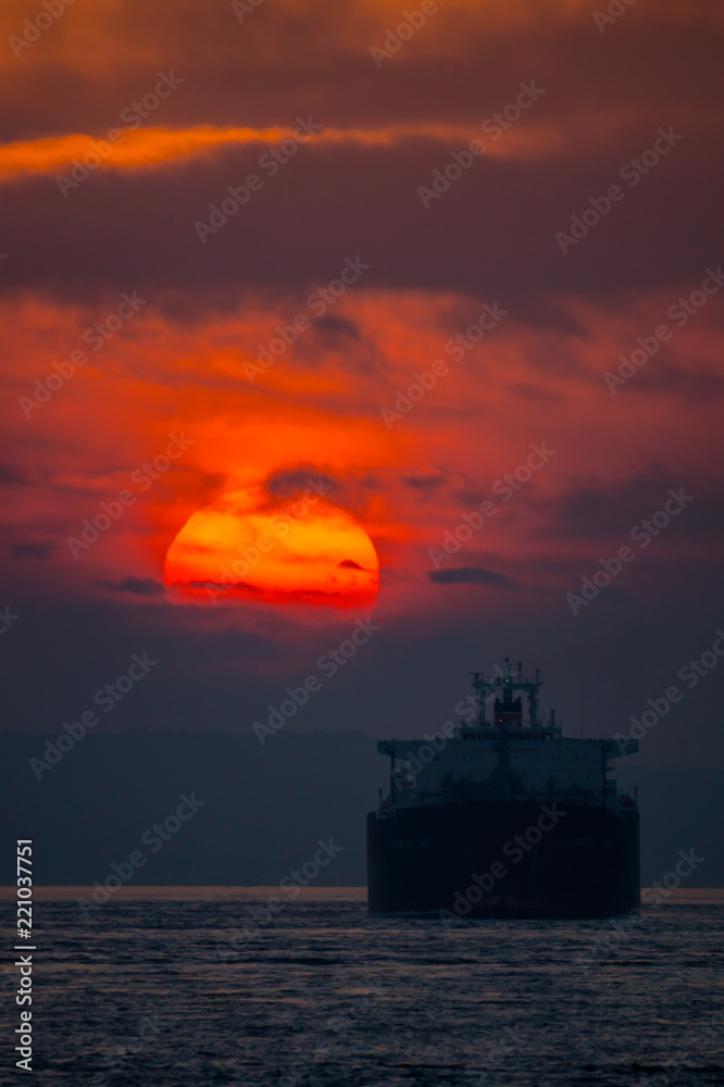 日の出と関門海峡に入る船影