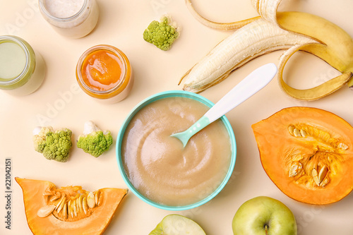 Flat lay composition with bowl of healthy baby food on color background