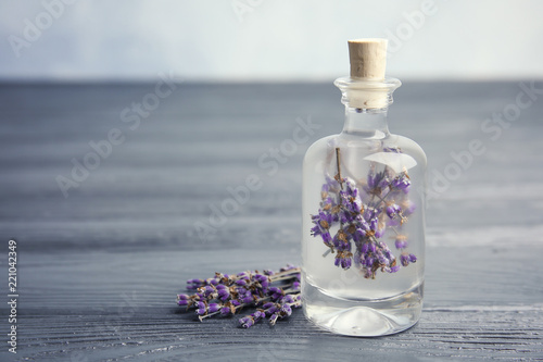Fototapeta Naklejka Na Ścianę i Meble -  Natural herbal oil and lavender flowers on wooden table. Space for text