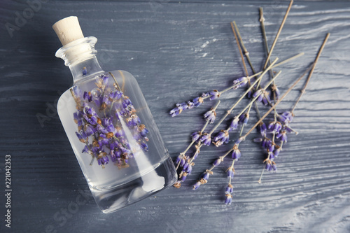 Fototapeta Naklejka Na Ścianę i Meble -  Flat lay composition with natural herbal oil and lavender flowers on wooden background
