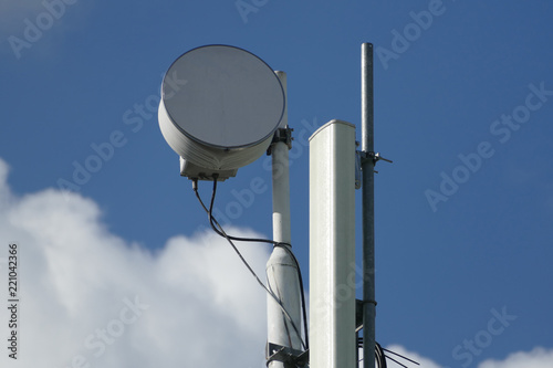 Cellphone telecommunication tower with clouds and blue sky